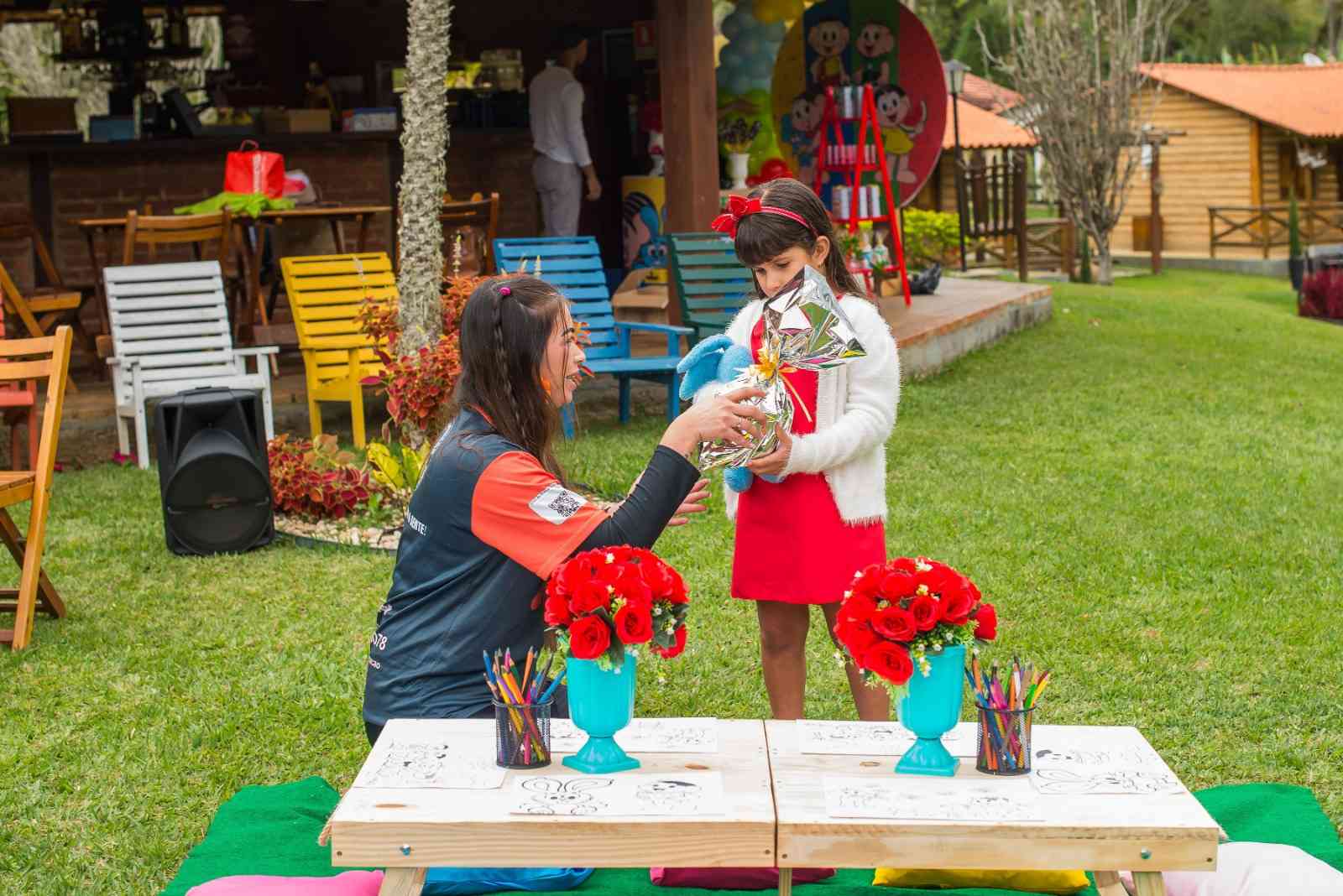 Crianças em atividade com recreador junto à mesa no jardim