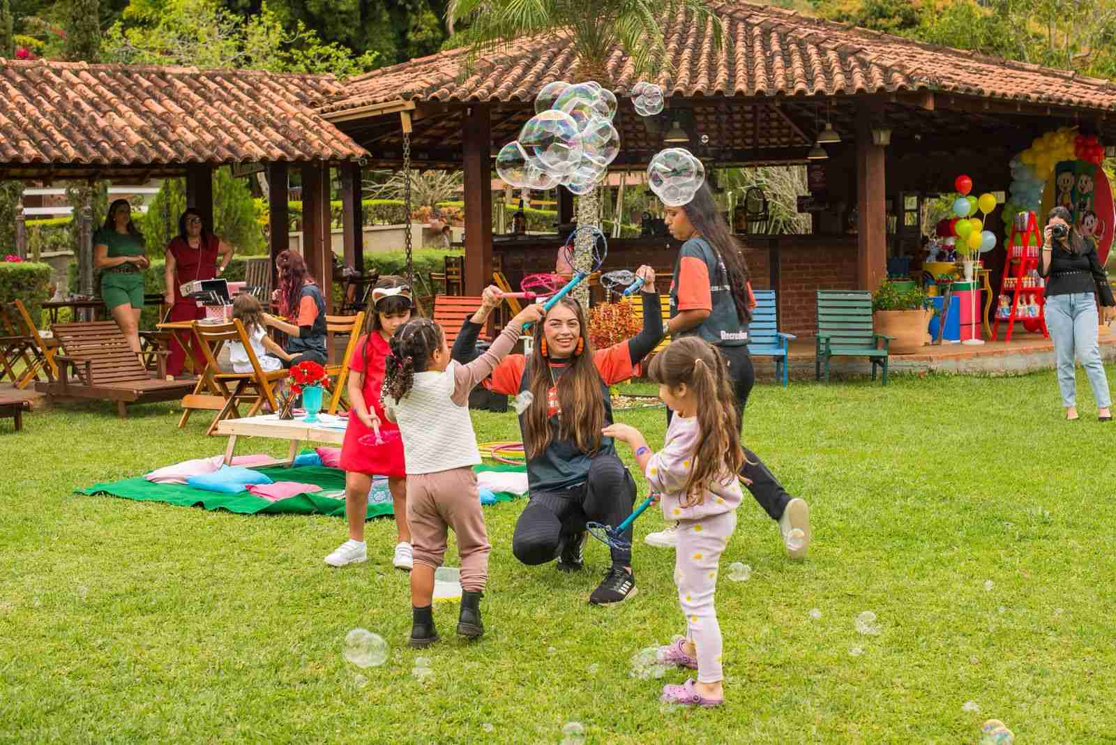 Crianças brincando com bolhas de sabão no jardim